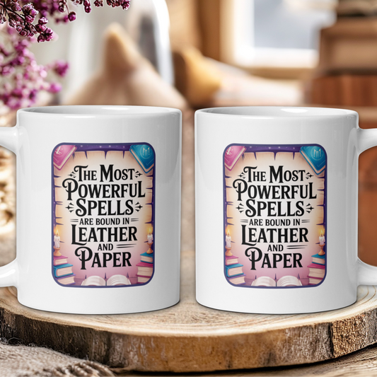 Two white mugs with a decorative design and text on a wooden surface.