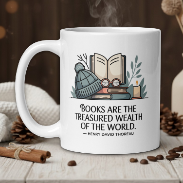 White mug with book-themed design and quote, placed on a wooden surface with decorative elements.