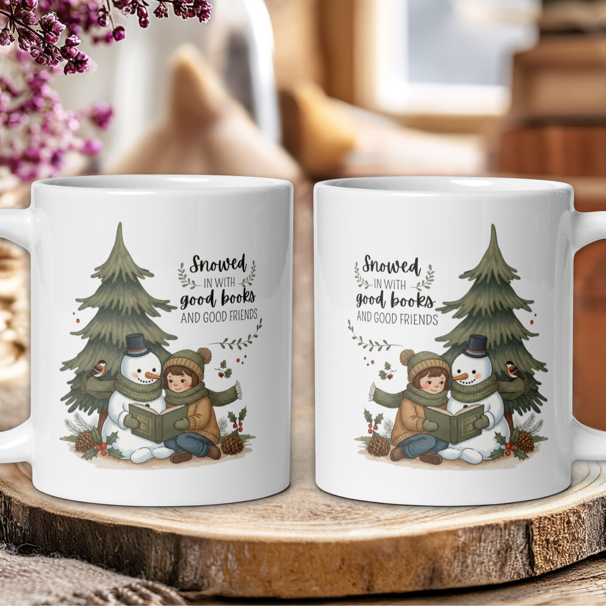 Two white mugs with winter-themed design featuring a snowman, child, and tree on a wooden surface.