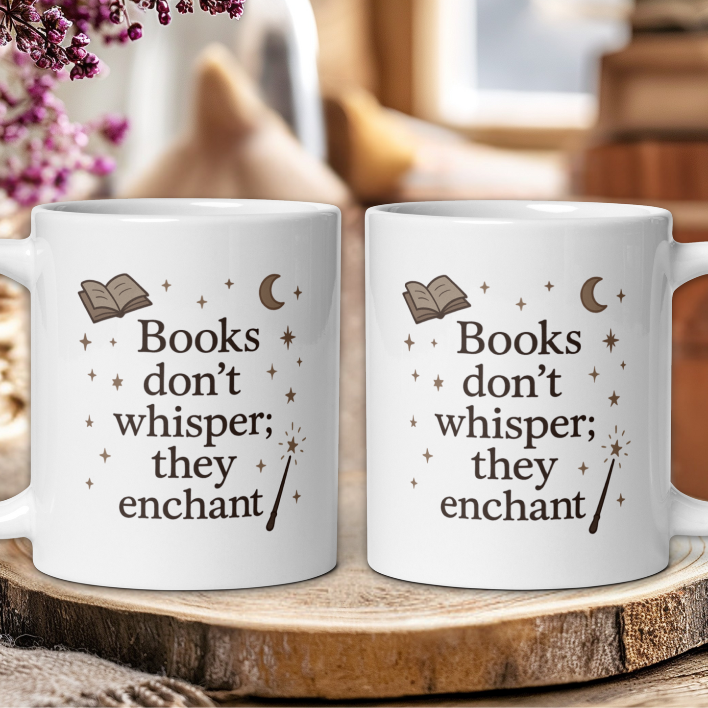 Two white mugs with a quote on a wooden surface, surrounded by flowers.