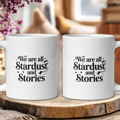 Two white mugs with text on a wooden surface, blurred background