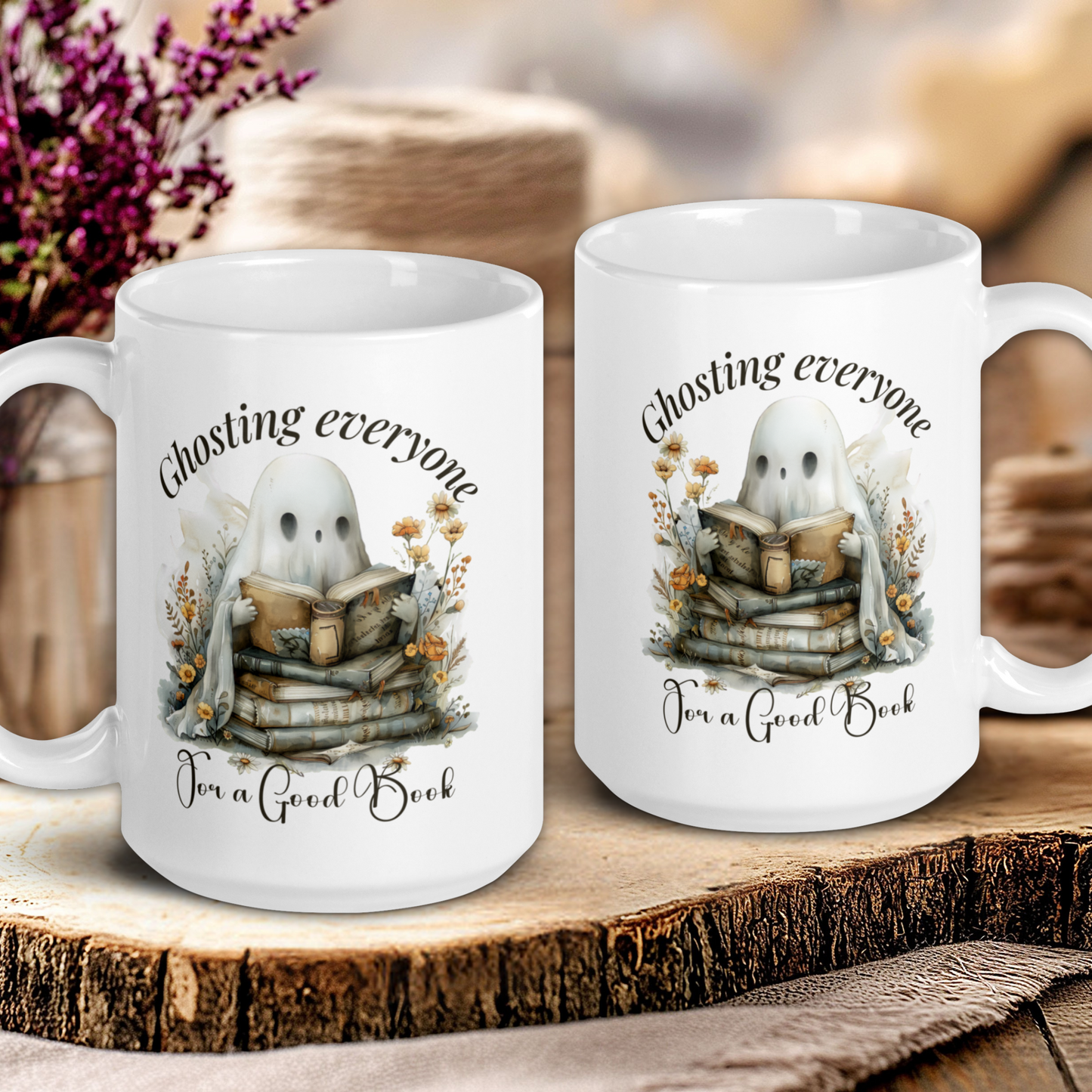 Two white mugs with ghost and book design on a wooden surface.