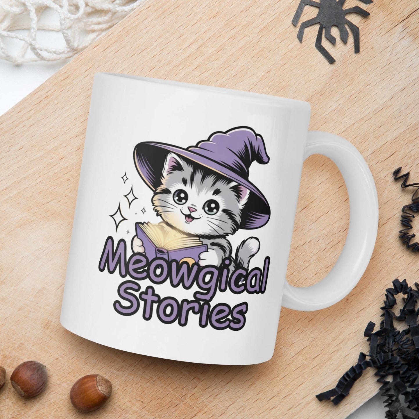 White mug with a cat in a witch hat design and 'Meowgical Stories' text on a wooden board with decorative elements.