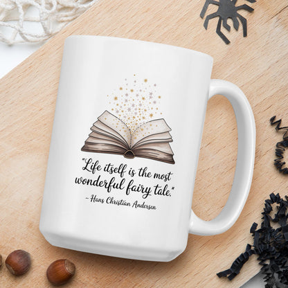 White mug with book design and quote on a wooden board with nuts and spider decorations.