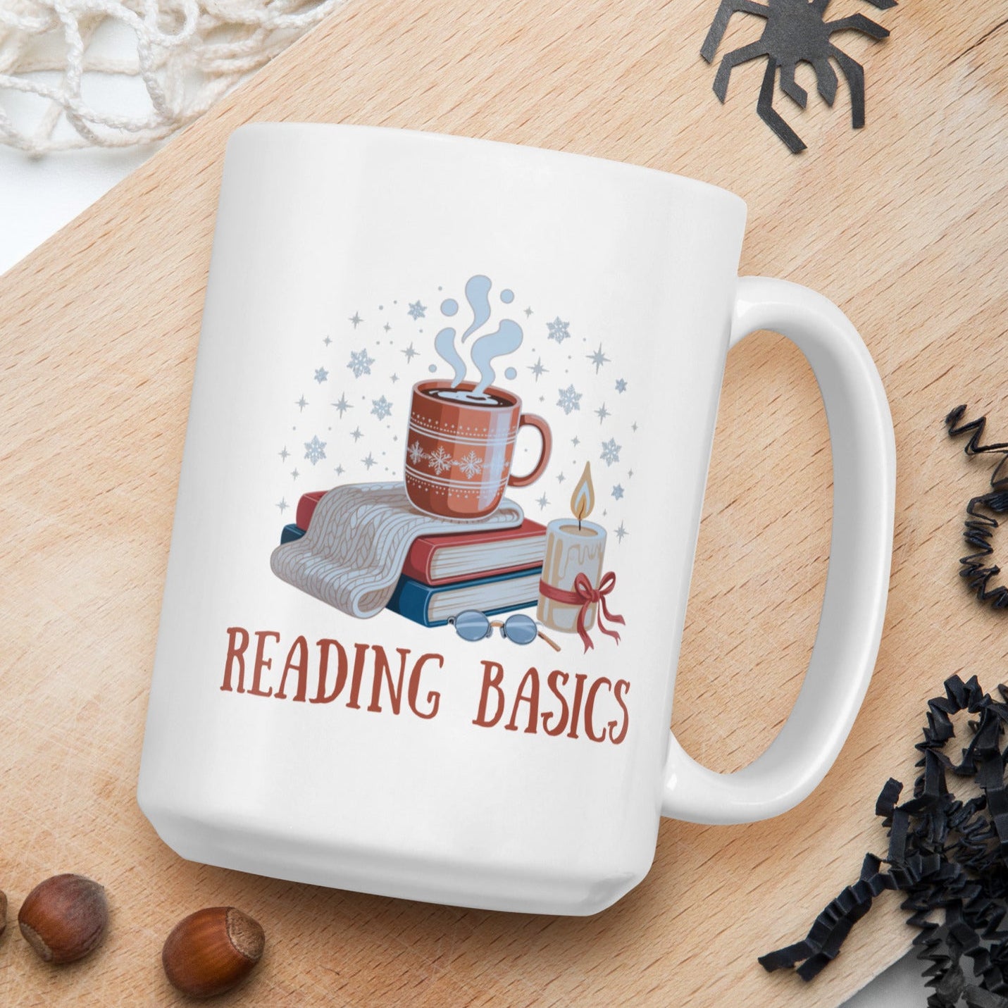 White mug with 'Reading Basics' design on a wooden board with nuts and spider decorations.